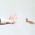 Two hands reaching toward one another