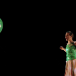 A person in a green dress sees a green balloon floating away