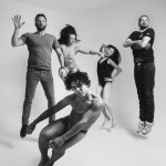 Black and white photo of five people jumping in the air