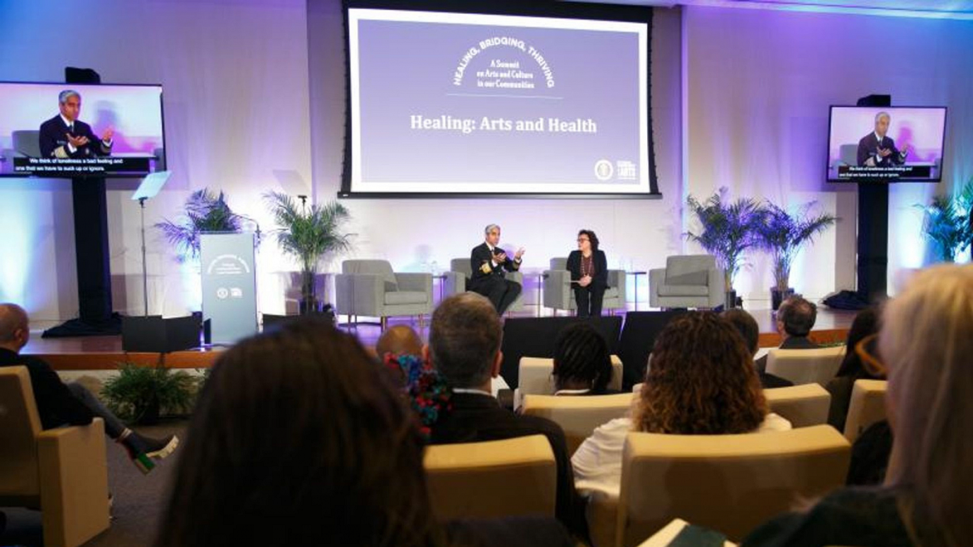 Audience view of two seated people having a discussion onstage  *NEA Chair Maria Rosario Jackson talks with U.S. Surgeon General Vice Admiral Vivek H. Murthy during the NEA/White House Domestic Policy Council-sponsored summit, Healing, Bridging, Thriving: A Summit on Arts and Culture in Our Communities. Photo courtesy of Shutterstock for NEA*